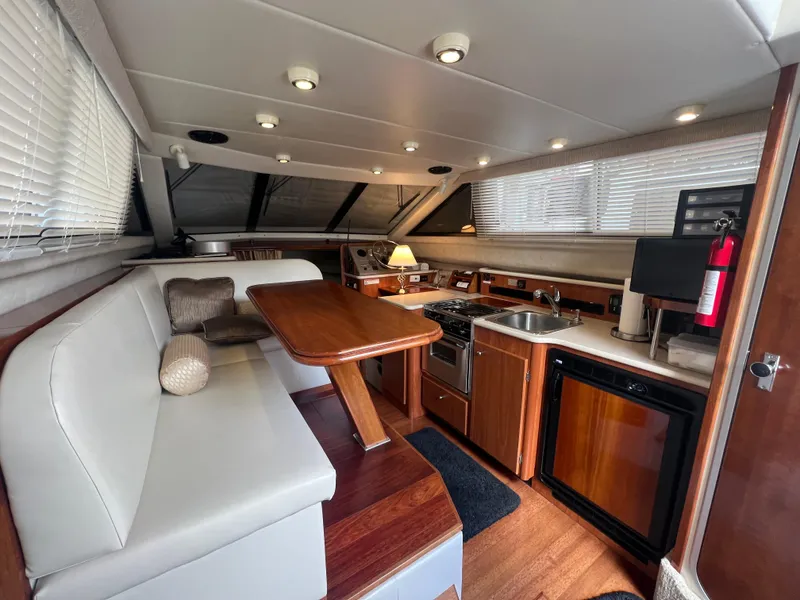 Slide: The Image of 2004 Bayliner 288 Ciara Classic Command Bridge interior with kitchen, dining area, and modern amenities. - 19