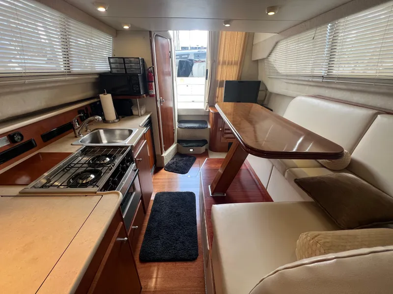 Slide: The Image of 2004 Bayliner 288 Ciara Classic Command Bridge interior with kitchen and dining area. - 21