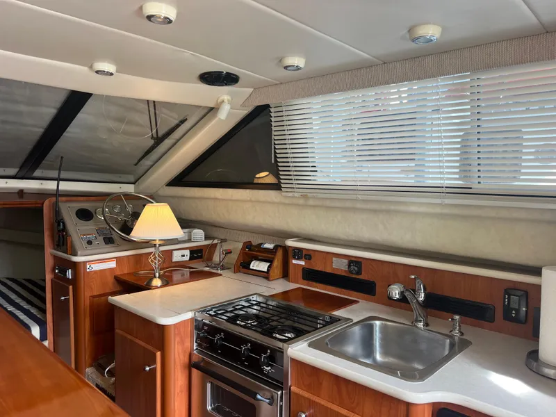 Slide: The Image of 2004 Bayliner 288 Ciara Classic Command Bridge interior with kitchen and helm. - 23