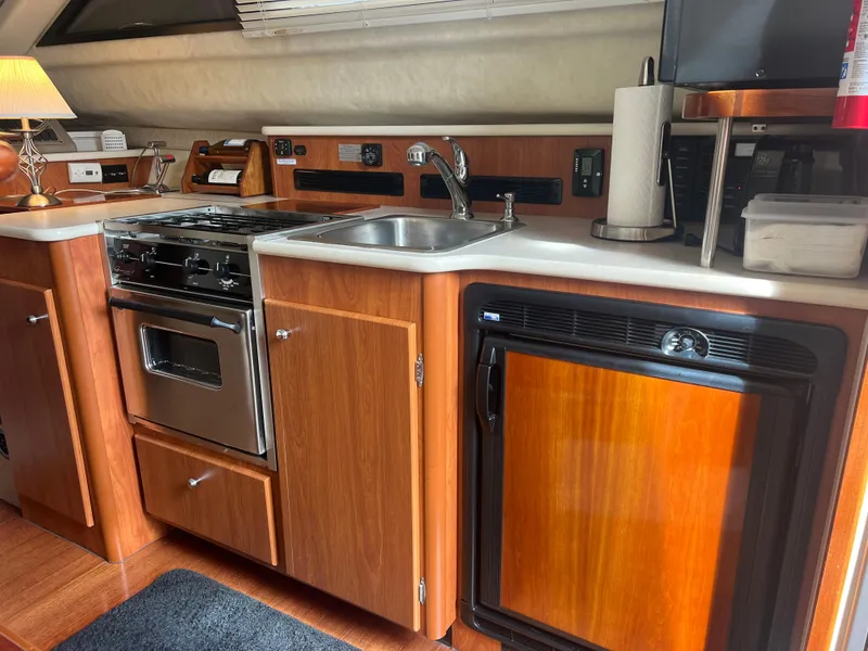 Slide: The Image of 2004 Bayliner 288 Ciara Classic Command Bridge kitchen with stove, sink, and fridge. - 25