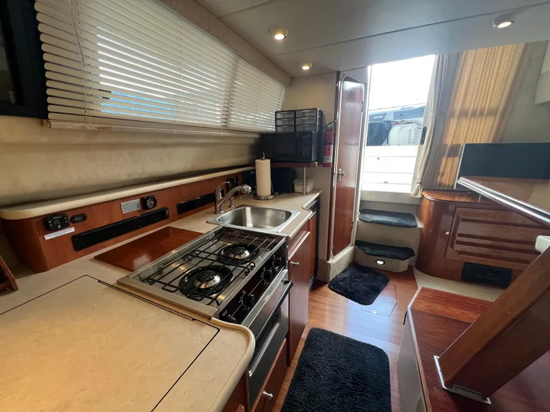 Slide: The Image of 2004 Bayliner 288 Ciara Classic Command Bridge interior with kitchen and stairs. - 28