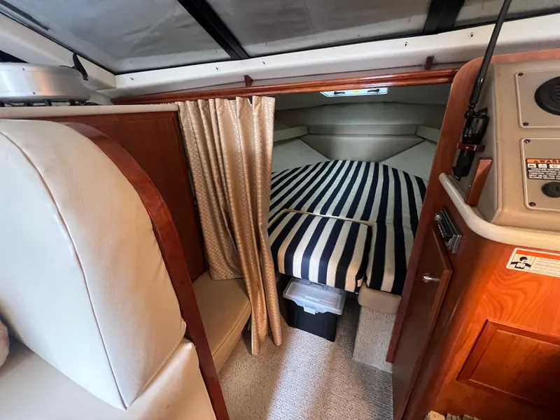 Slide: The Image of 2004 Bayliner 288 Ciara Classic Command Bridge cabin with striped bedding and wood accents. - 29