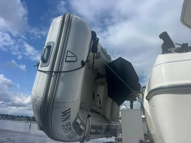 Slide: The Image of 2004 Bayliner 2858 Ciara Classic Command Bridge with inflatable boat, under a cloudy sky. - 3