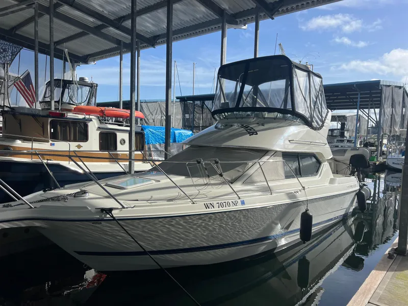 Slide: The Image of 2004 Bayliner 2858 Ciara Classic Command Bridge docked in a marina under a covered shelter. - 49