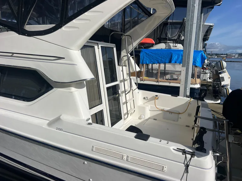 Slide: The Image of 2004 Bayliner 2858 Ciara Classic Command Bridge docked at marina, featuring spacious deck area. - 7