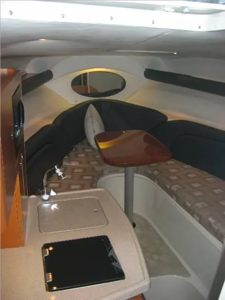 Slide: The Image of 2003 Four Winns 268 Vista cabin interior with seating, table, and kitchenette. - 6