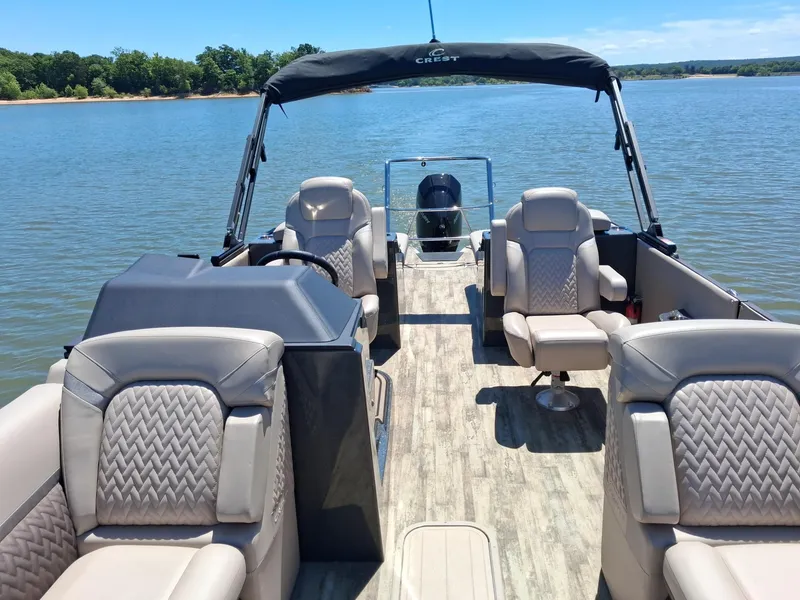 Slide: The Image of 2025 Crest Caribbean 230 SLRC pontoon boat on a serene lake. - 4