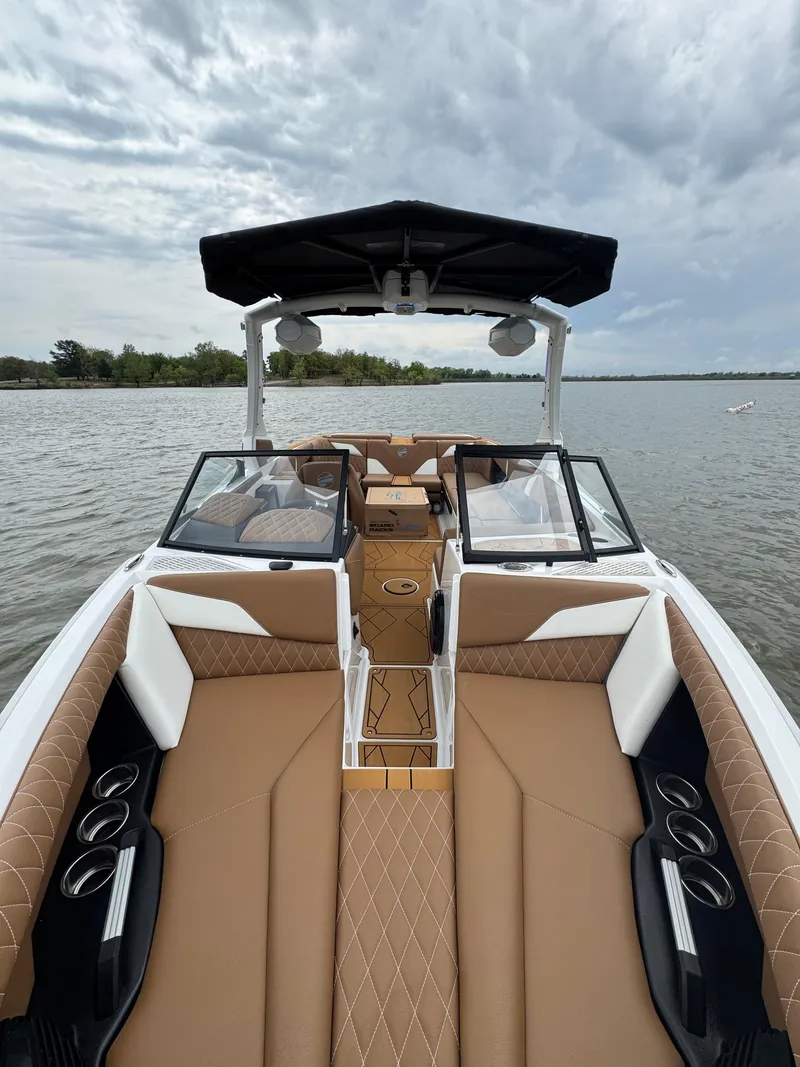 Slide: The Image of 2025 Tigé Z5 boat interior with tan seating, black accents, and open water view. - 11