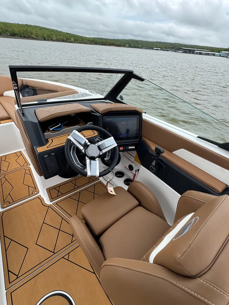 Slide: The Image of 2025 Tigé Z5 boat interior with modern dashboard, steering wheel, and luxurious seating on a lake. - 14