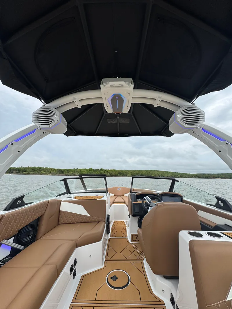 Slide: The Image of 2025 Tigé Z5 boat interior with luxurious seating and advanced sound system on a calm lake. - 15