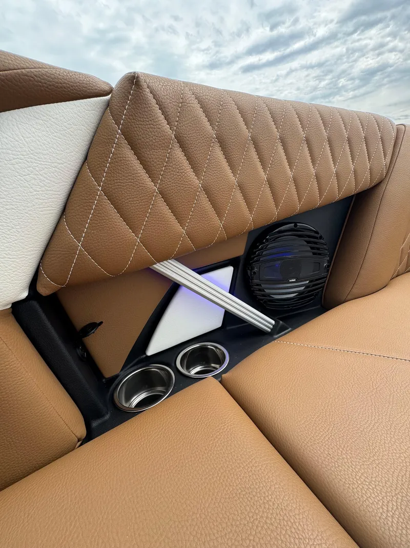 Slide: The Image of 2025 Tigé Z5 boat interior with quilted brown leather seats and built-in speaker system. - 16