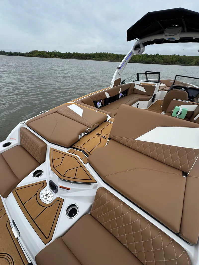 Slide: The Image of 2025 Tigé Z5 boat with luxurious brown seating on a calm lake. - 6