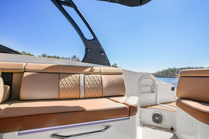 Slide: The Image of 2017 Sea Ray SDX 270 Outboard interior with tan seating, blue sky, and lake view. - 11
