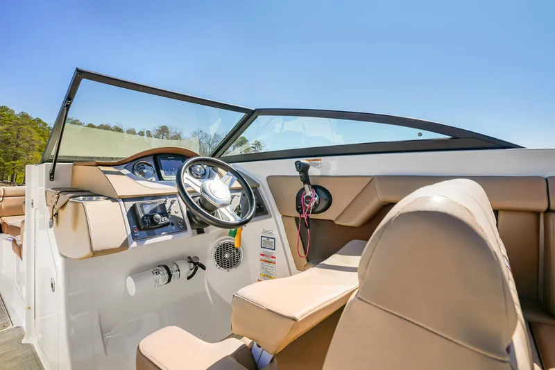Slide: The Image of 2017 Sea Ray SDX 270 Outboard boat interior with steering wheel and beige seating. - 12