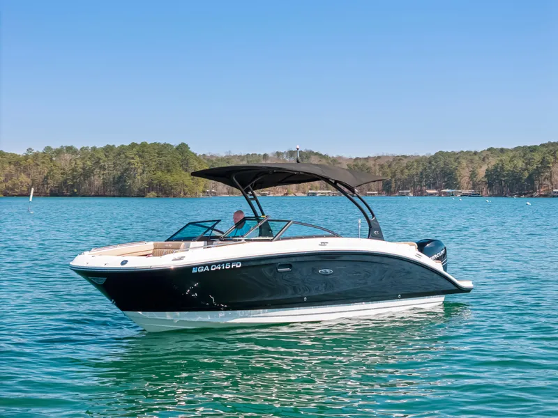Slide: The Image of 2017 Sea Ray SDX 270 Outboard boat on a serene lake with forested shoreline. - 2