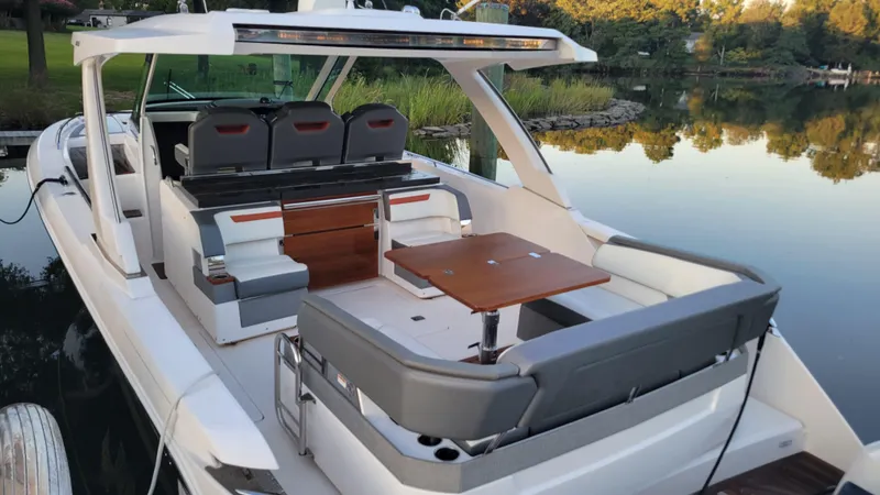 Slide: The Image of 2019 Tiara Sport 38 LS luxury boat with spacious seating and elegant design on a serene lake. - 2