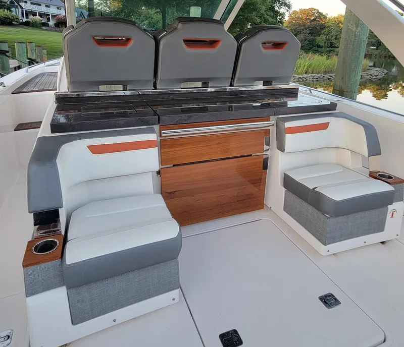 Slide: The Image of 2019 Tiara Sport 38 LS boat interior with stylish seating and wooden accents. - 9