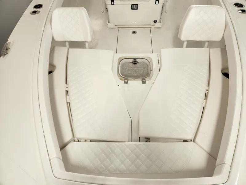 Slide: The Image of 2025 BlackJack 256 Coastal boat interior with white cushioned seating and storage compartments. - 14