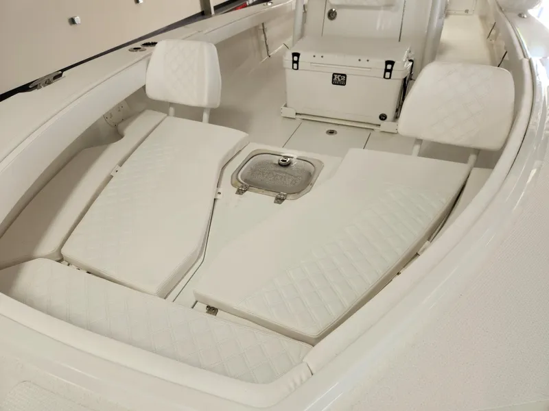 Slide: The Image of 2025 BlackJack 256 Coastal boat interior with white cushioned seating and storage compartments. - 15
