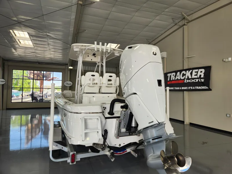 Slide: The Image of 2025 BlackJack 256 Coastal boat in showroom, featuring powerful outboard motor. - 3