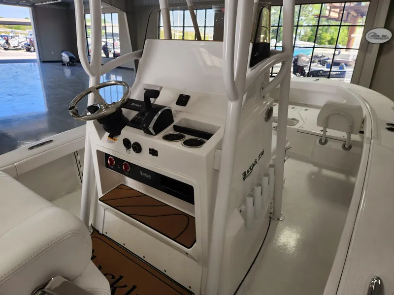 Slide: The Image of 2025 BlackJack 256 Coastal boat interior with steering console and seating. - 7