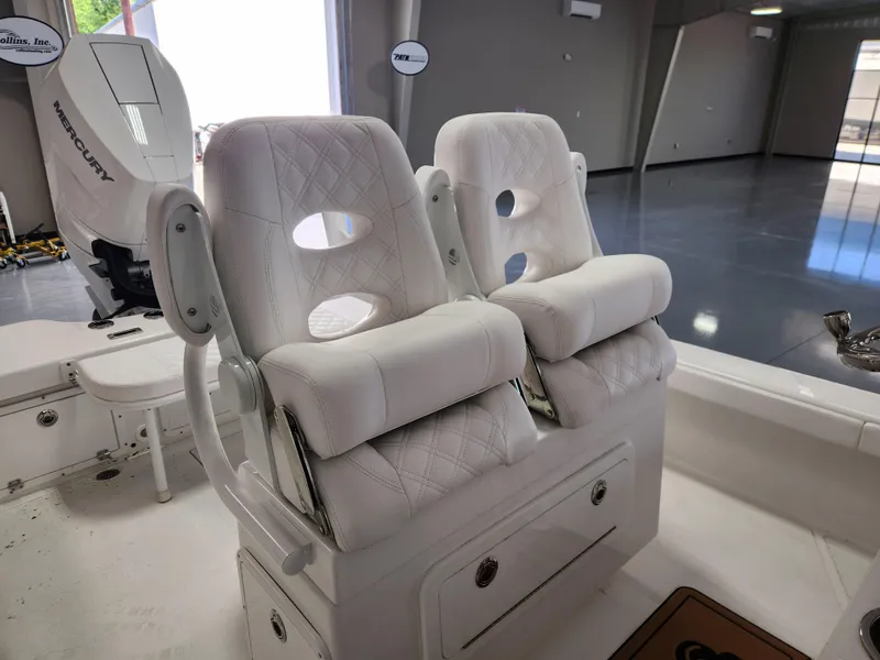 Slide: The Image of 2025 BlackJack 256 Coastal boat with white cushioned seats and Mercury engine in a showroom. - 9