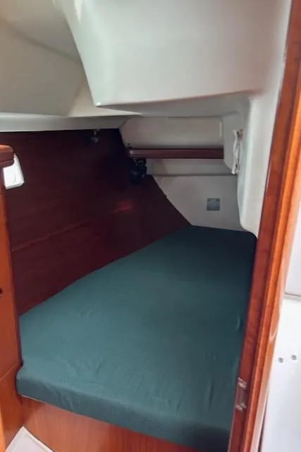 Slide: The Image of 2001 Beneteau 361 cabin interior with green bedding and wooden accents. - 22