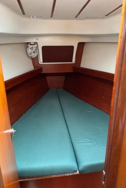 Slide: The Image of 2001 Beneteau 361 cabin interior with teal cushions and wooden trim. - 24