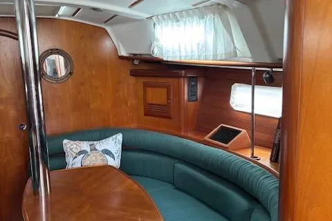 Slide: The Image of Interior of 2001 Beneteau 361 sailboat with wood finish and curved seating area. - 28