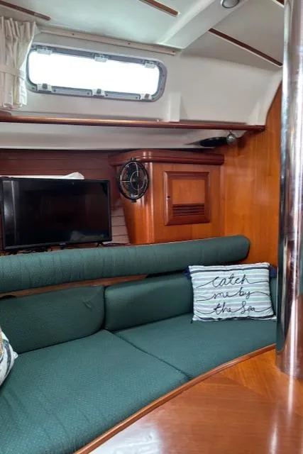 Slide: The Image of Interior of 2001 Beneteau 361 sailboat with green seating and decorative pillows. - 31
