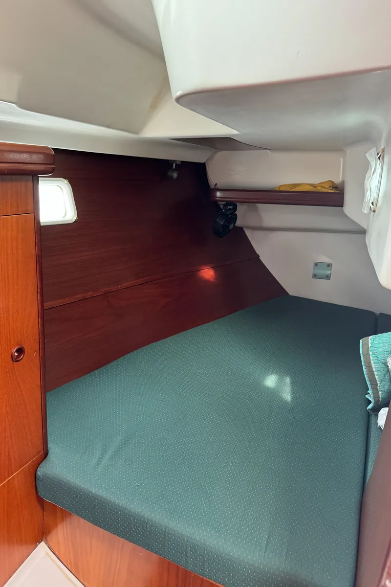 Slide: The Image of 2001 Beneteau 361 cabin interior with wooden finish and green bedding. - 34