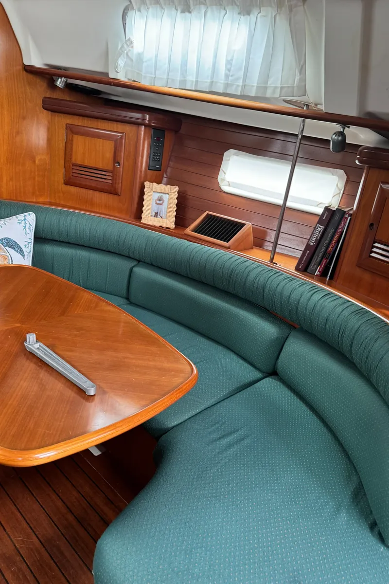 Slide: The Image of Interior of 2001 Beneteau 361 sailboat with green seating and wooden table. - 37