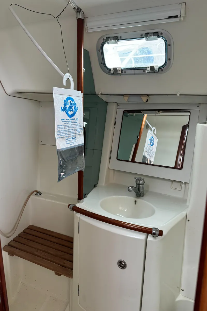 Slide: The Image of 2001 Beneteau 361 yacht bathroom with sink, mirror, and wooden bench. - 40