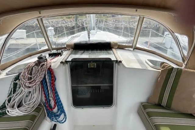 Slide: The Image of 2001 Beneteau 361 sailboat cockpit with ropes and striped cushions, showcasing helm and deck view. - 6