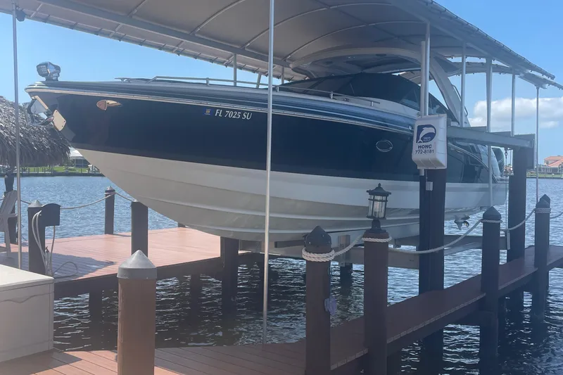 Slide: The Image of 2020 Formula 350 Crossover Bowrider OB on a boat lift at a dock. - 3