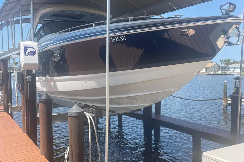 Slide: The Image of 2020 Formula 350 Crossover Bowrider OB on a boat lift by the water. - 4