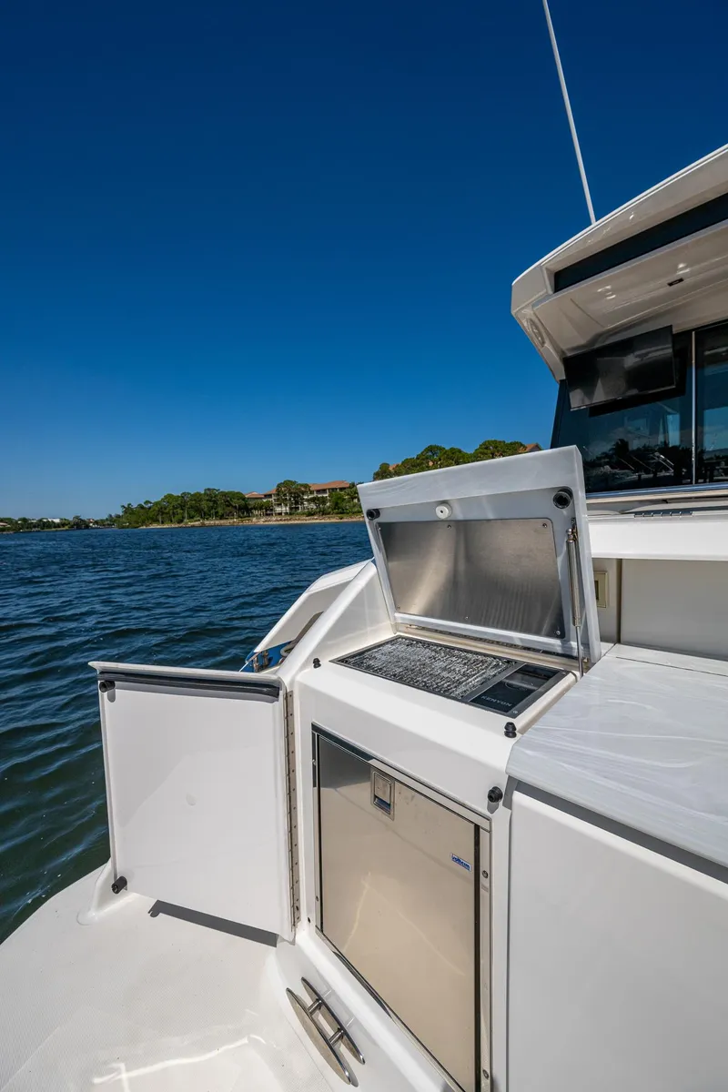 Slide: The Image of 2020 Tiara Yachts C53 Coupe, outdoor kitchen area, scenic water view. - 12