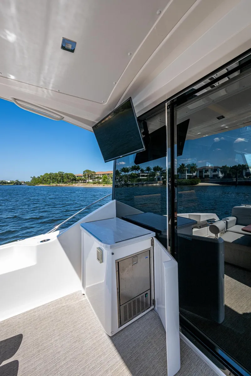 Slide: The Image of 2020 Tiara Yachts C53 Coupe, outdoor deck view with TV and ocean backdrop. - 13