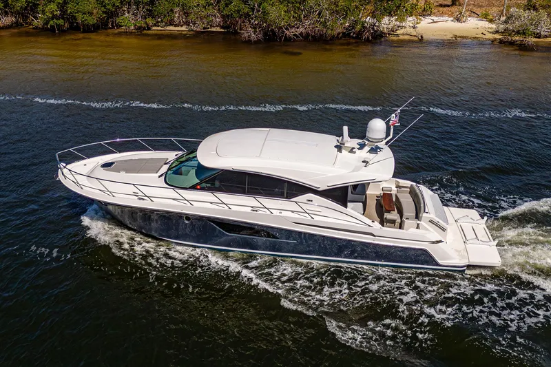 Slide: The Image of 2020 Tiara Yachts C53 Coupe cruising on a scenic waterway. - 2