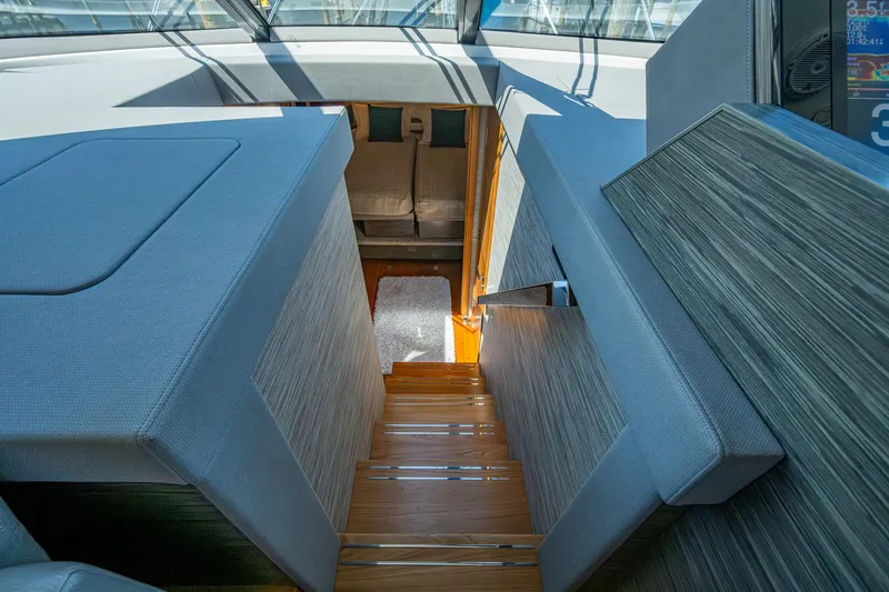 Slide: The Image of Interior view of 2020 Tiara Yachts C53 Coupe, featuring modern stairs and seating. - 24