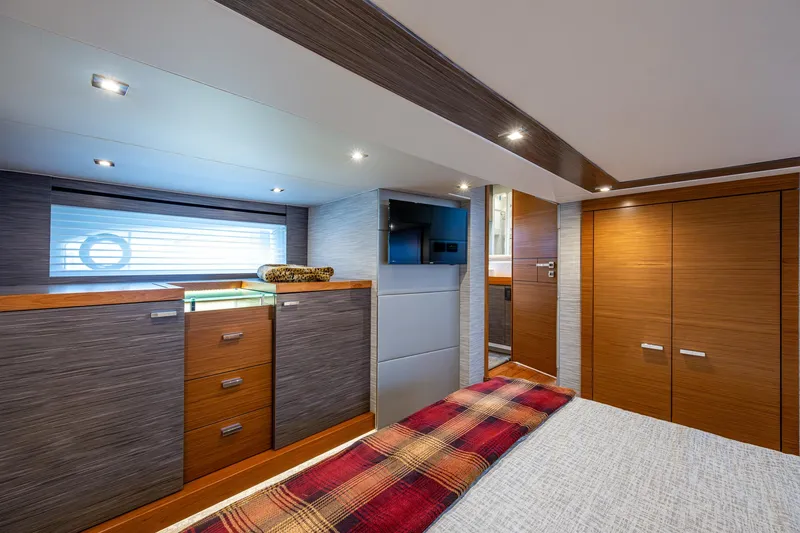 Slide: The Image of 2020 Tiara Yachts C53 Coupe interior cabin with modern wood finishes and cozy bedding. - 33