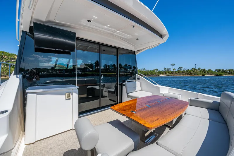 Slide: The Image of 2020 Tiara Yachts C53 Coupe, luxurious outdoor seating, sleek design, waterfront view. - 8