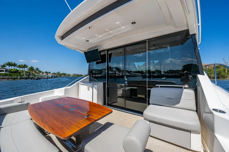 Slide: The Image of 2020 Tiara Yachts C53 Coupe, elegant outdoor seating, scenic waterfront view. - 9