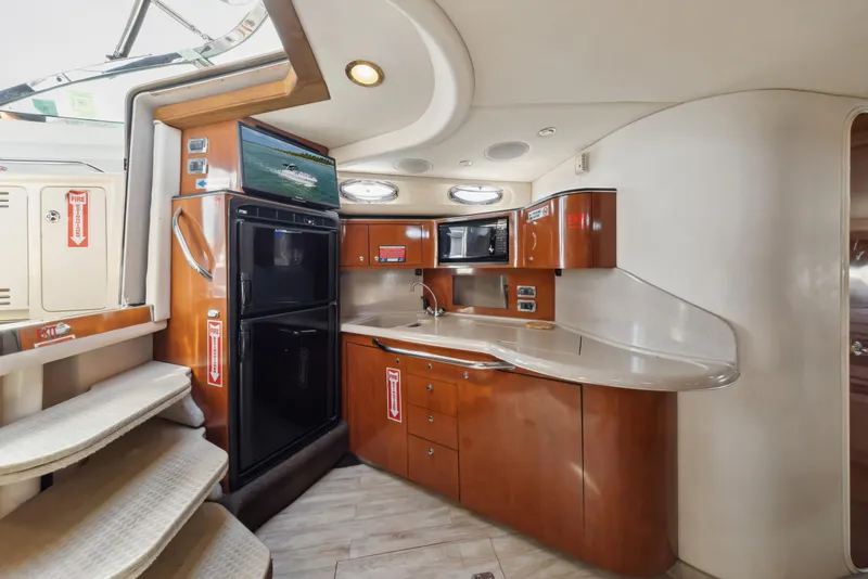 Slide: The Image of 2003 Sea Ray 380 Sundancer yacht interior with modern kitchen and wooden cabinetry. - 12