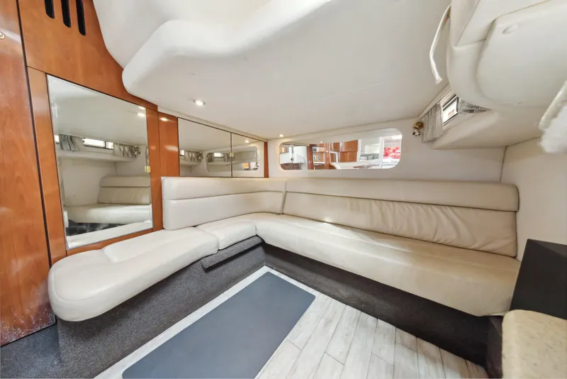 Slide: The Image of 2003 Sea Ray 380 Sundancer interior with beige leather seating and wood accents. - 16