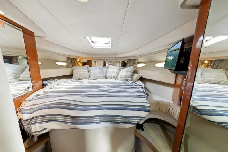 Slide: The Image of Luxurious cabin interior of 2003 Sea Ray 380 Sundancer yacht with cozy bed and striped bedding. - 21