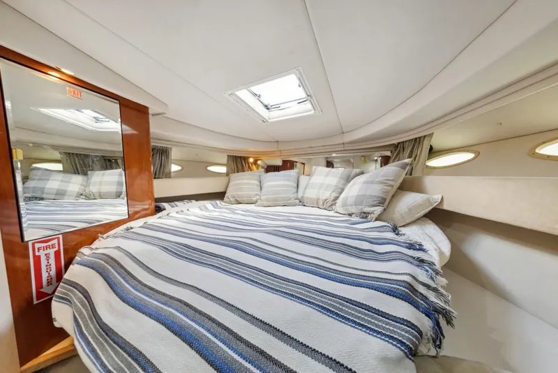 Slide: The Image of Cozy cabin interior of 2003 Sea Ray 380 Sundancer with striped bedding and skylight. - 22