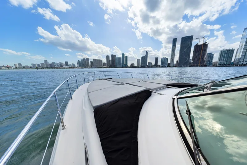 Slide: The Image of 2003 Sea Ray 380 Sundancer cruising with city skyline in the background. - 25