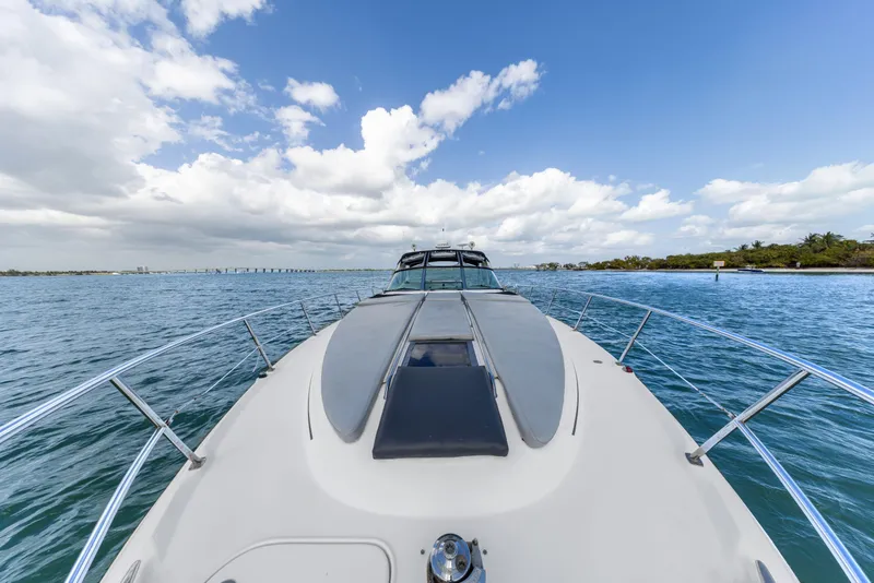 Slide: The Image of 2003 Sea Ray 380 Sundancer cruising on open water under a blue sky. - 27