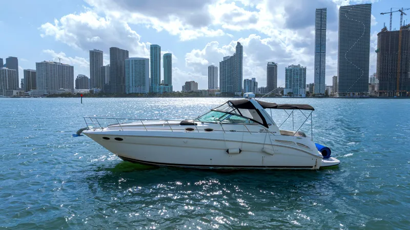 Slide: The Image of 2003 Sea Ray 380 Sundancer yacht cruising near city skyline on a sunny day. - 29